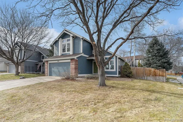 a white house that has a tree in front of it