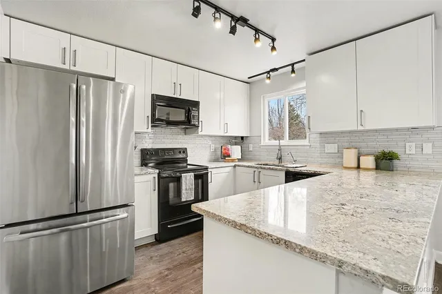 a kitchen with granite countertop a refrigerator stove and sink