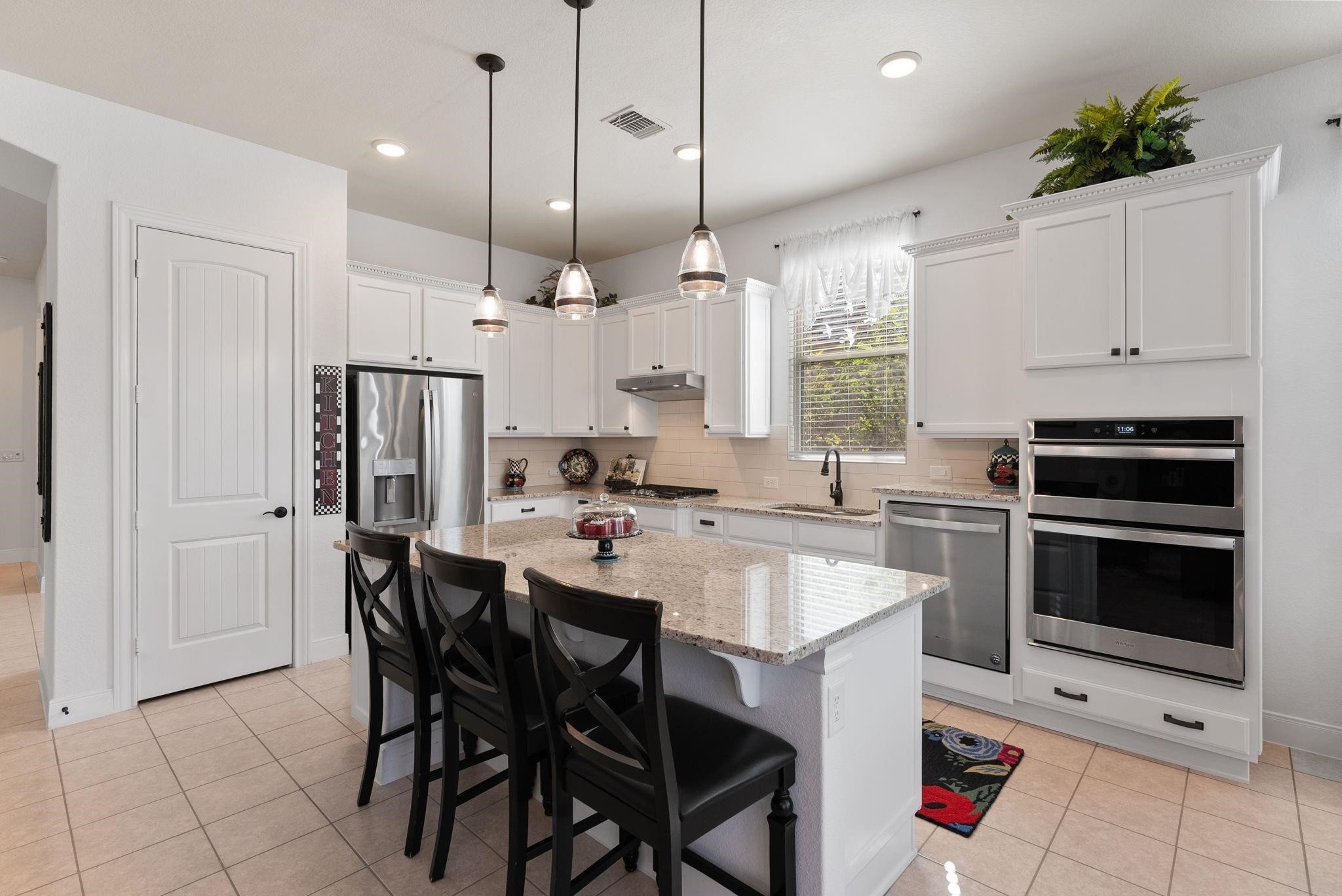 230 Galloway Court Spring, TX 77382 - Photo 12 of 32 a kitchen with stainless steel appliances kitchen island a table chairs and a refrigerator
