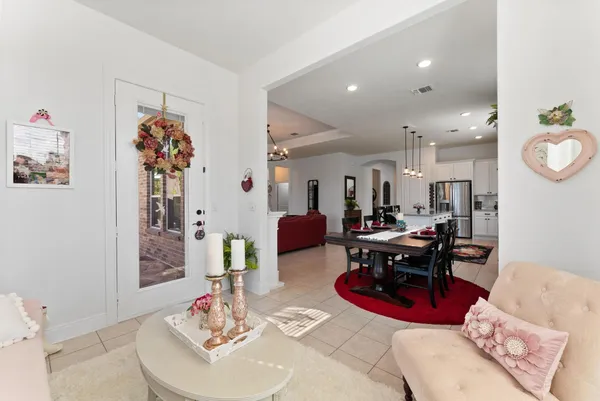 a kitchen with kitchen island granite countertop a table chairs microwave and refrigerator