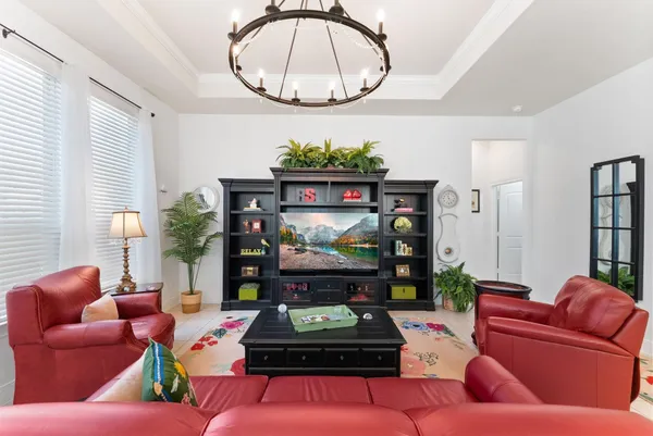 a living room with furniture a rug kitchen view and a chandelier