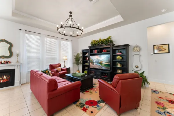 a living room with furniture a dining table and a chandelier