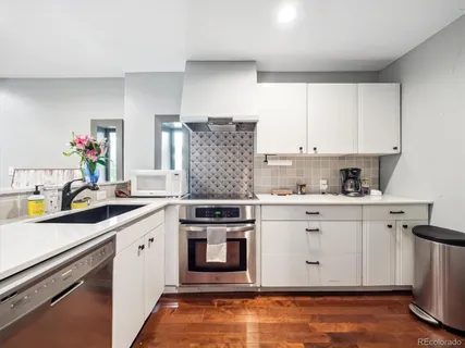 a kitchen with stainless steel appliances granite countertop a stove and white cabinets