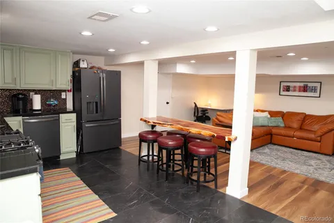 a kitchen with stainless steel appliances granite countertop a stove refrigerator and sink