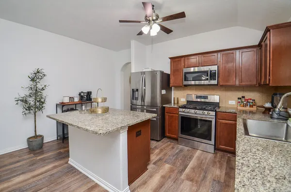a kitchen with stainless steel appliances granite countertop a sink stove and refrigerator