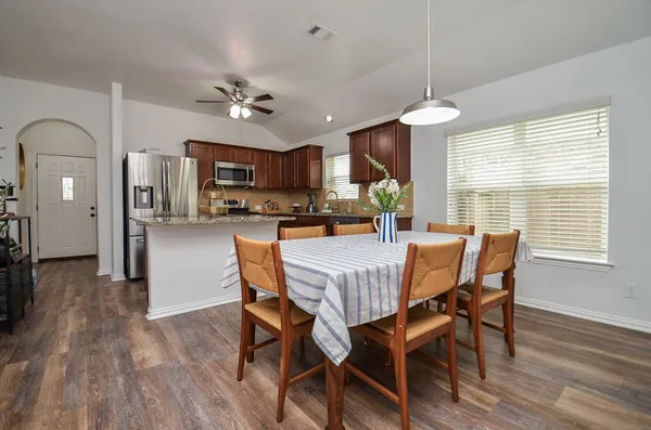 a dining room with furniture a window and wooden floor