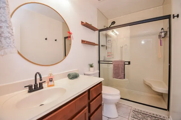 a bathroom with a sink a toilet and shower