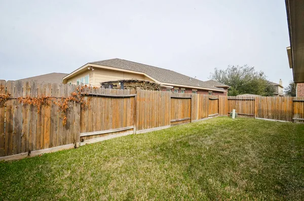 a view of a backyard with wooden fence