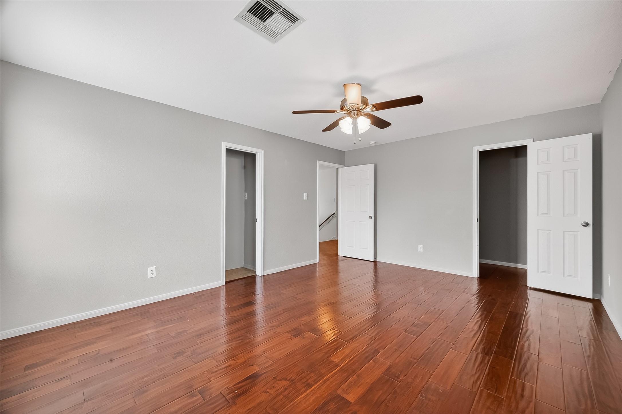 3131 Upland Spring Trace Katy, TX 77493 - Photo 32 of 48 a view of an empty room with wooden floor and a ceiling fan