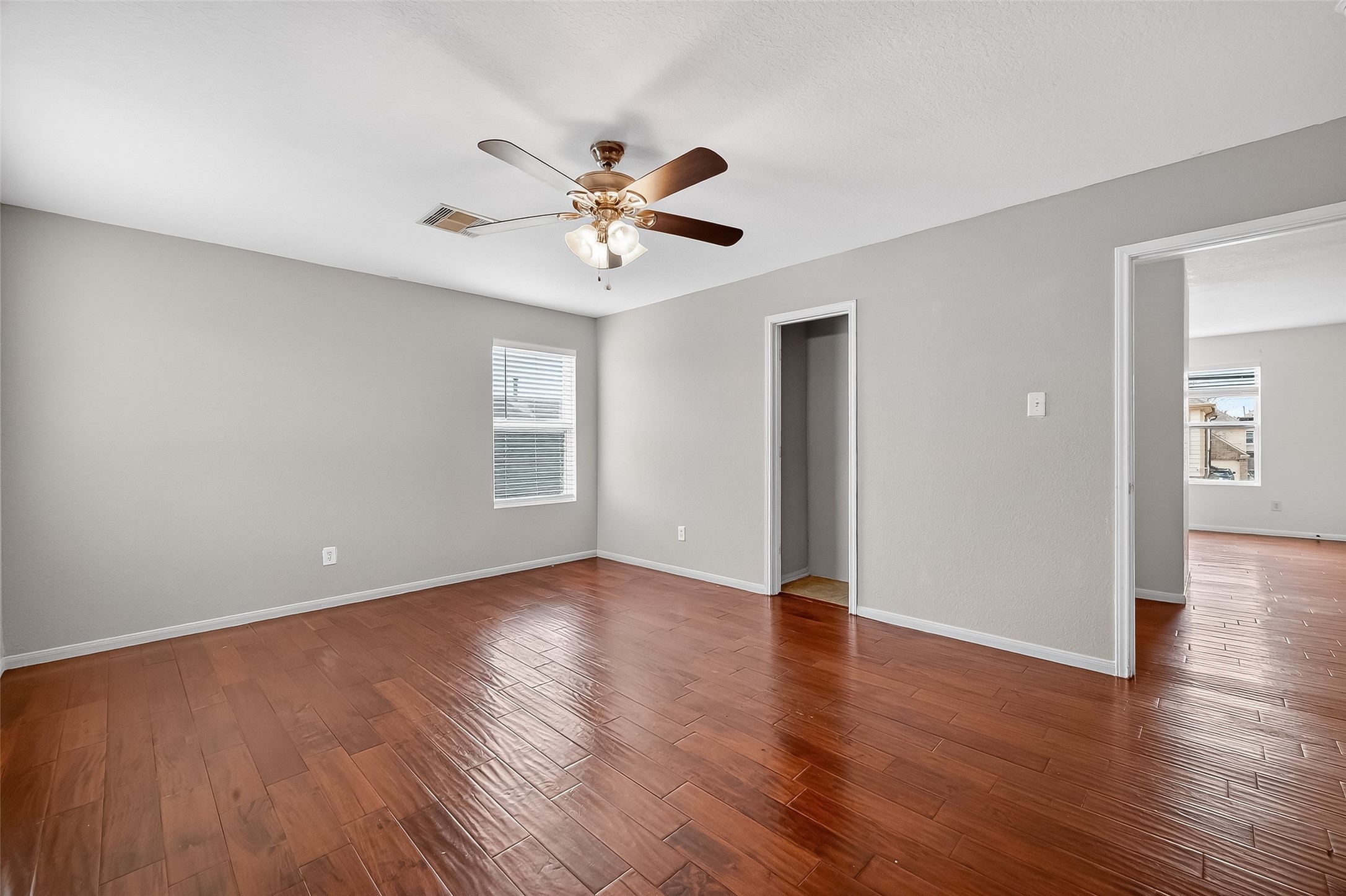 3131 Upland Spring Trace Katy, TX 77493 - Photo 33 of 48 a view of an empty room with wooden floor and a ceiling fan