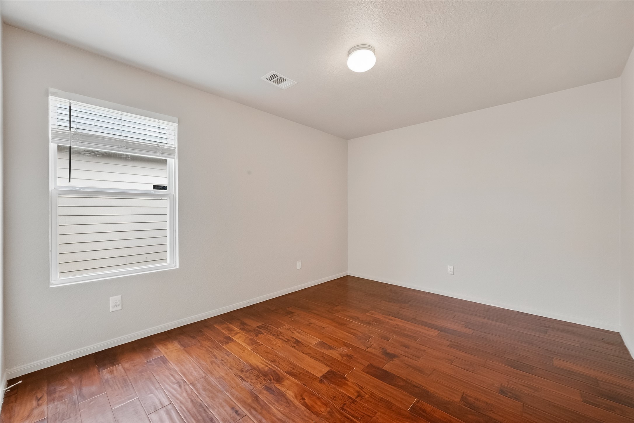 3131 Upland Spring Trace Katy, TX 77493 - Photo 36 of 48 a view of an empty room with wooden floor and a window