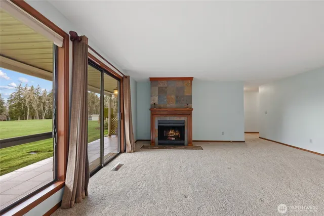 a view of an empty room with a fireplace and a floor to ceiling window
