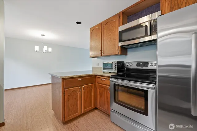 a kitchen with stainless steel appliances granite countertop a stove microwave and sink