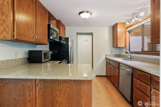 a kitchen with stainless steel appliances wooden cabinets a sink and a stove