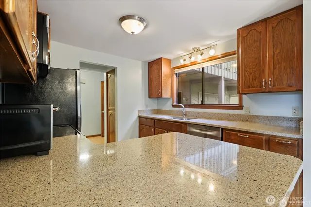 a kitchen with stainless steel appliances granite countertop a sink and a stove top oven