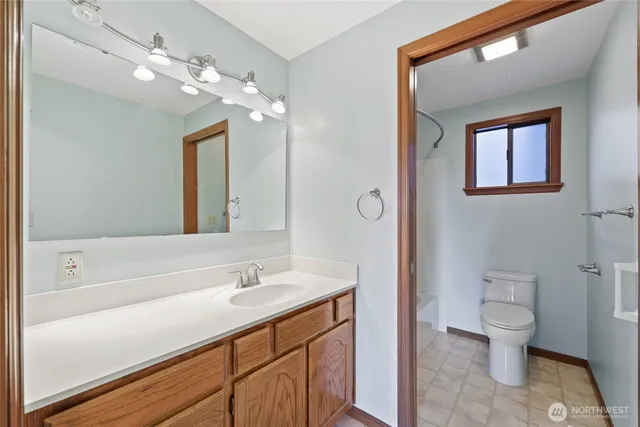 a bathroom with a sink a toilet and a mirror