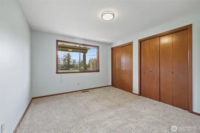 an empty room with windows and closet