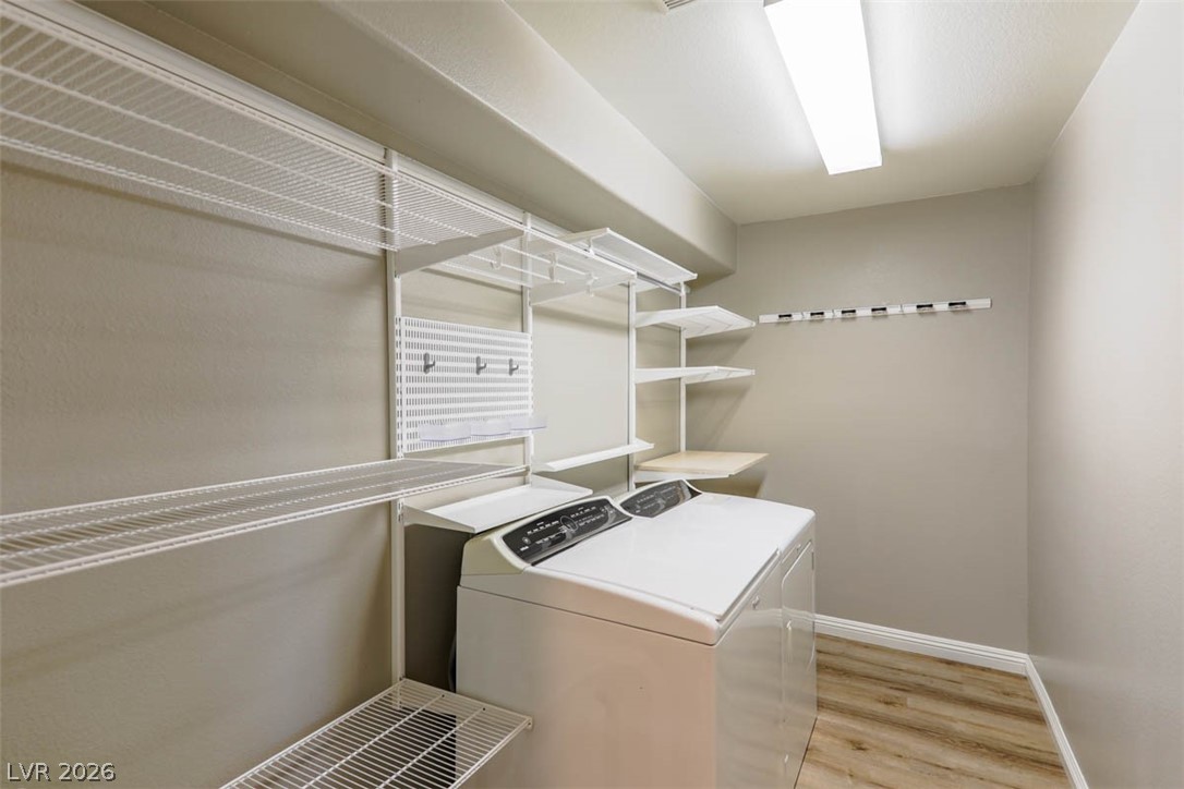 9940 Sable Point Street Las Vegas, NV 89178 - Photo 24 of 40 Laundry area with washing machine and dryer, light wood-type flooring, and baseboards