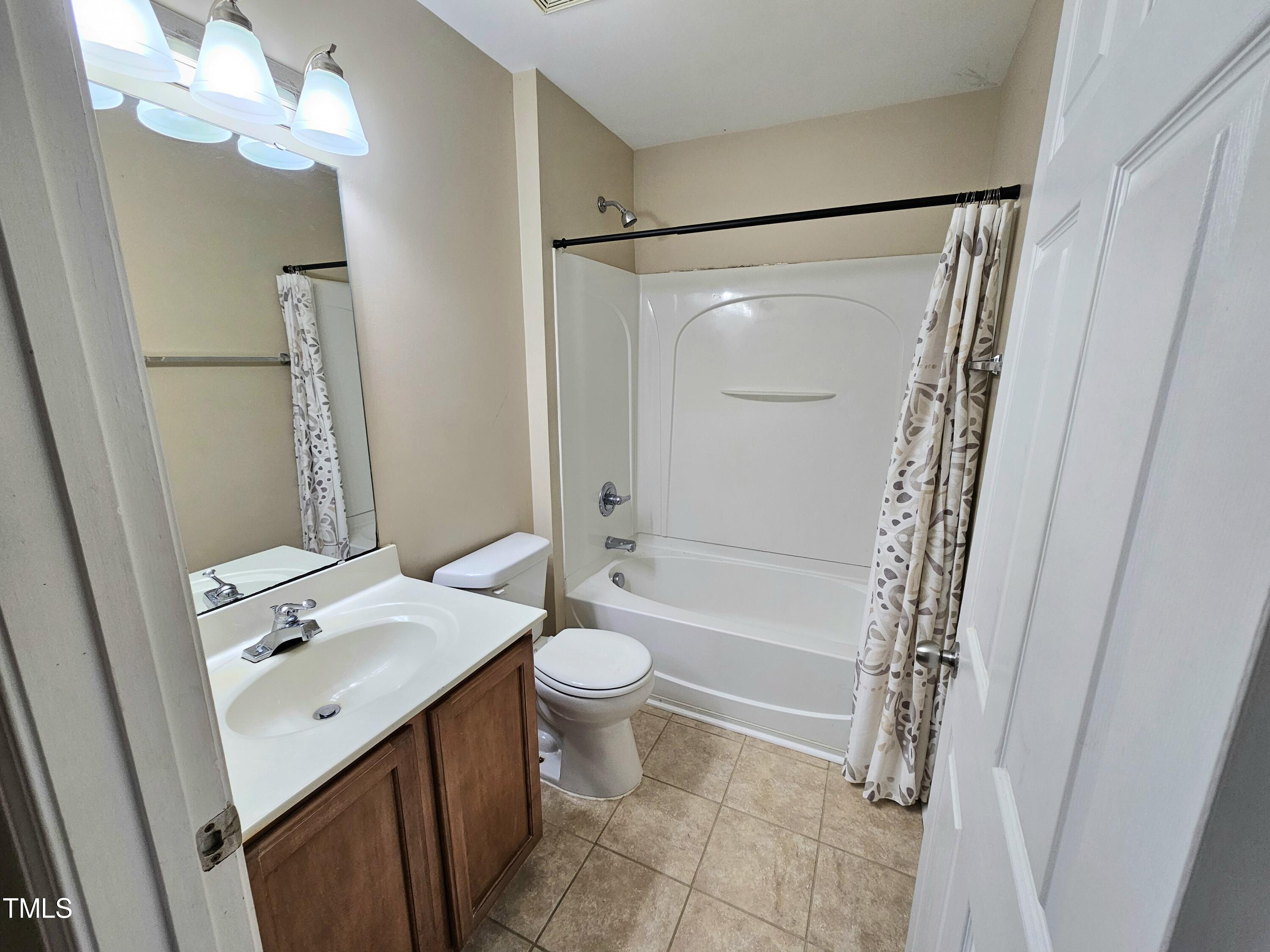 2220 Valley Edge Drive, Unit 107 Raleigh, NC 27614 - Photo 15 of 24 a bathroom with a sink a toilet and shower a mirror