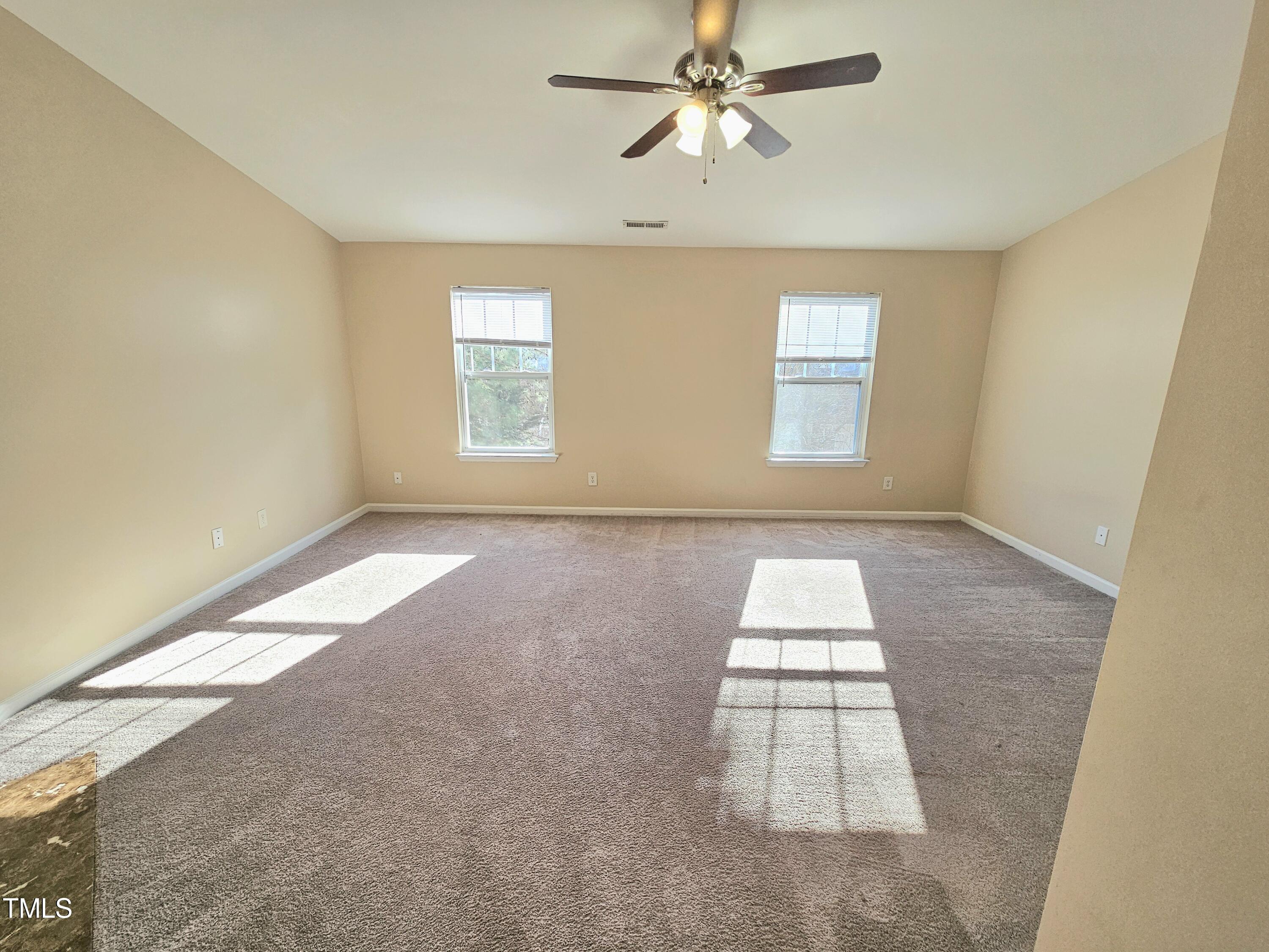 2220 Valley Edge Drive, Unit 107 Raleigh, NC 27614 - Photo 17 of 24 an empty room with windows and fan