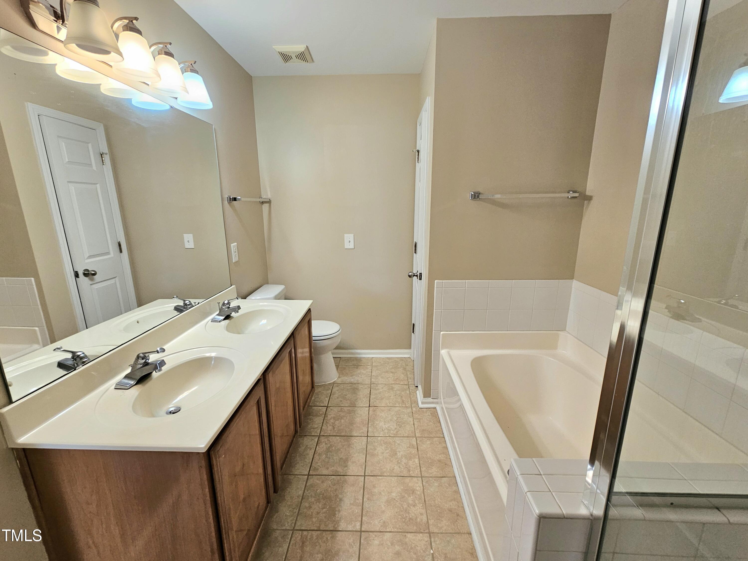 2220 Valley Edge Drive, Unit 107 Raleigh, NC 27614 - Photo 20 of 24 a bathroom with a tub sink vanity granite and a mirror