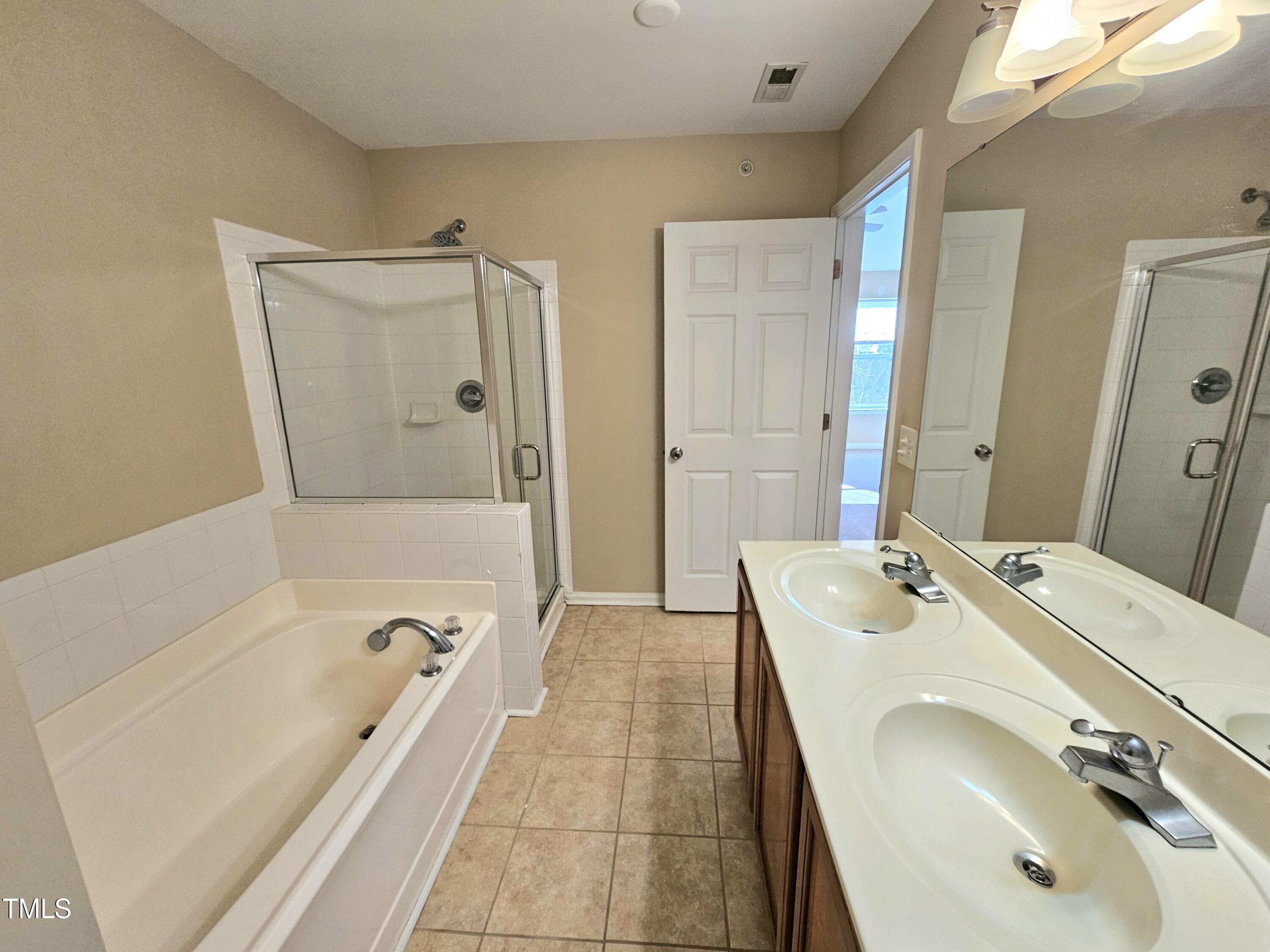 2220 Valley Edge Drive, Unit 107 Raleigh, NC 27614 - Photo 21 of 24 a bathroom with a tub sink and mirror