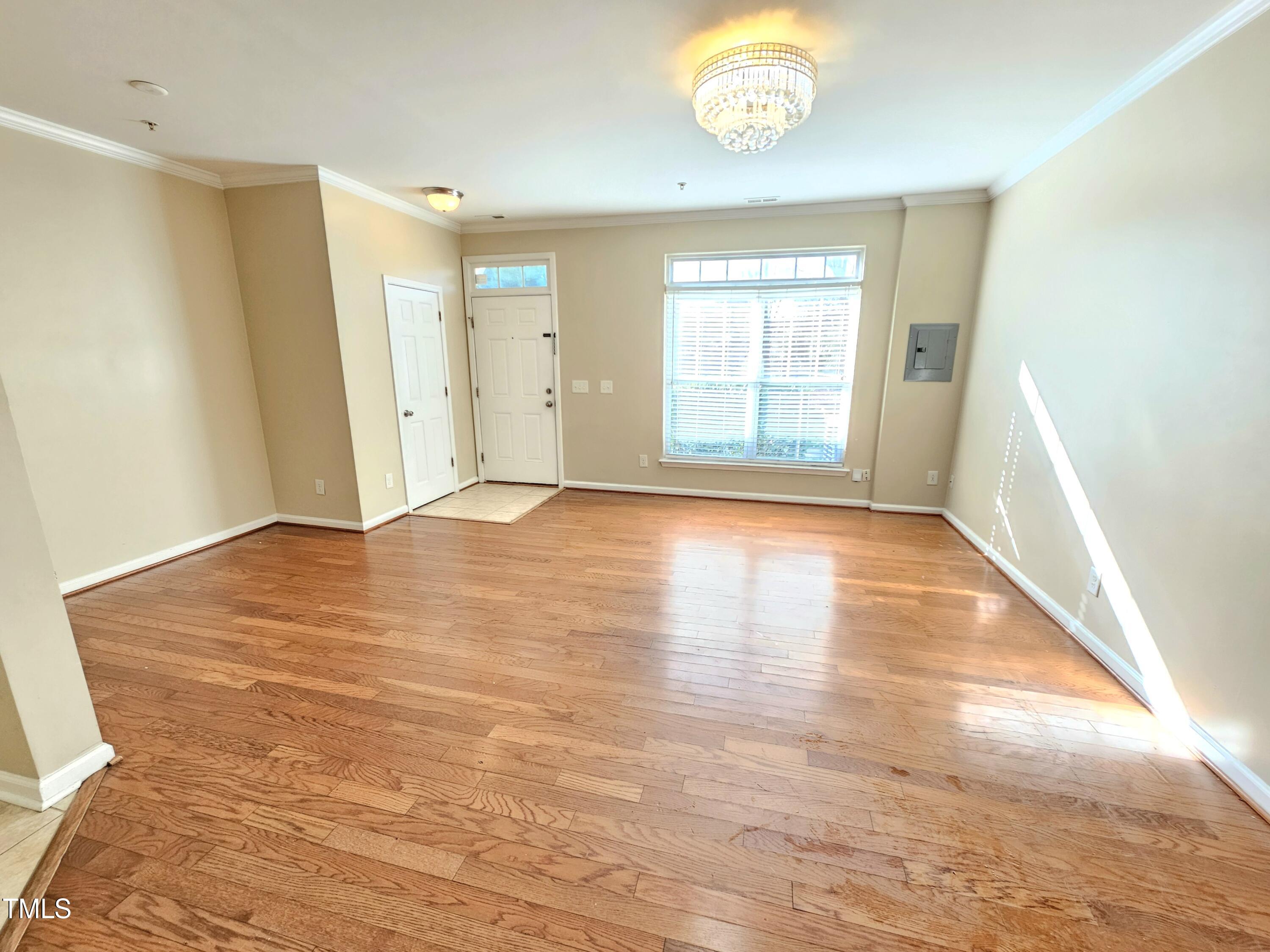 2220 Valley Edge Drive, Unit 107 Raleigh, NC 27614 - Photo 6 of 24 a view of an empty room with wooden floor and a window