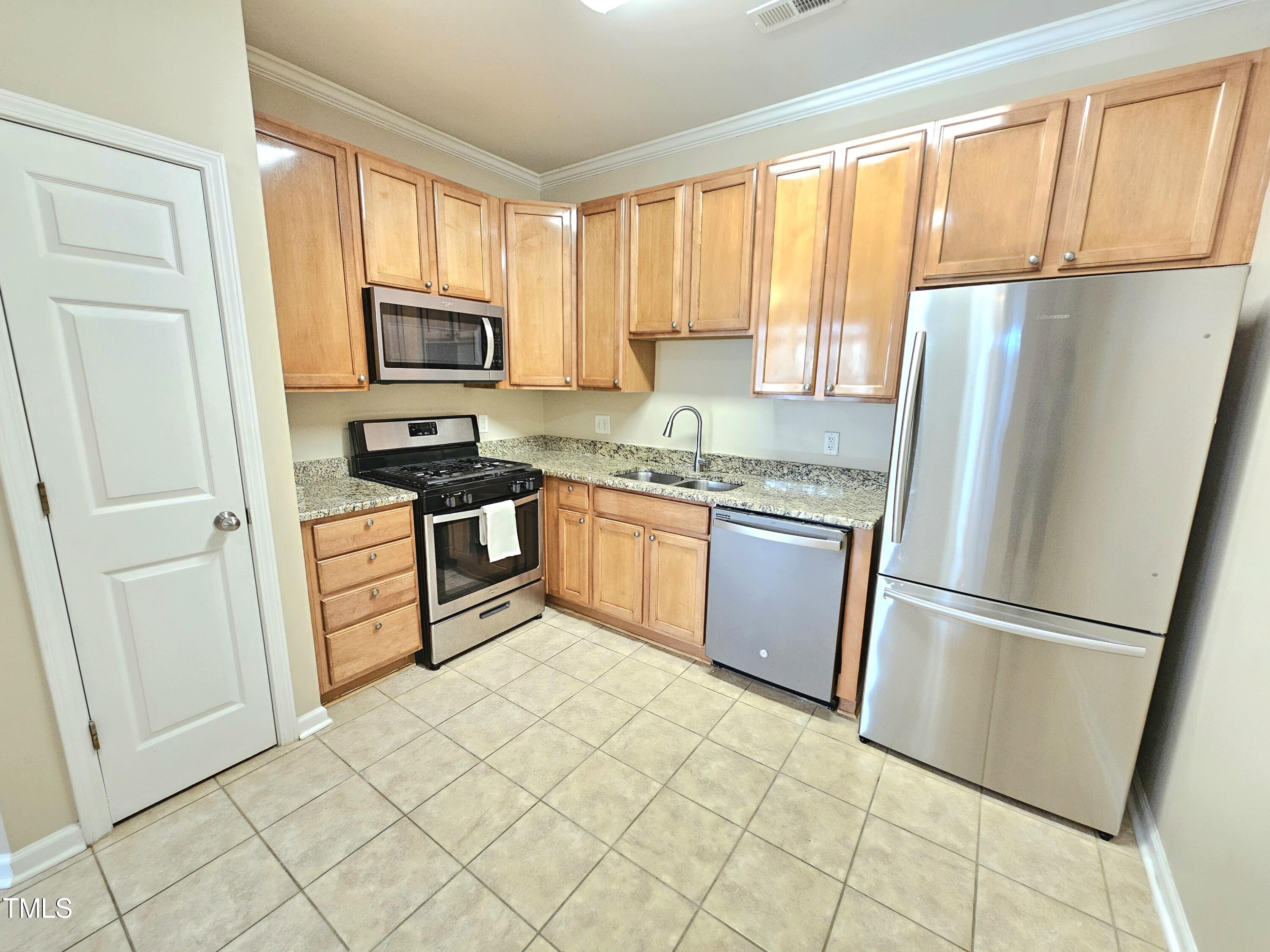 2220 Valley Edge Drive, Unit 107 Raleigh, NC 27614 - Photo 10 of 24 a kitchen with stainless steel appliances granite countertop a refrigerator stove sink and a window