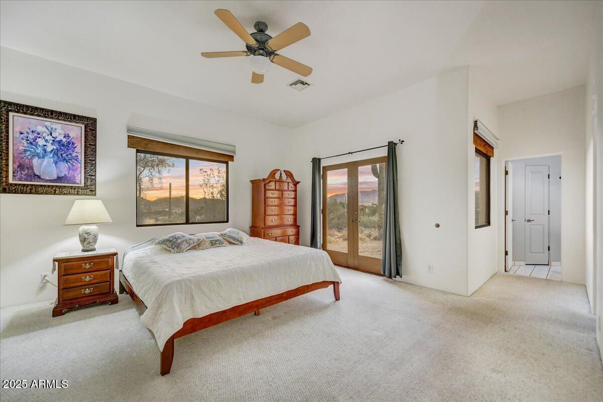 39258 North Ridgeway Drive Cave Creek, AZ 85331 - Photo 15 of 51 a bedroom with a large bed and a chandelier