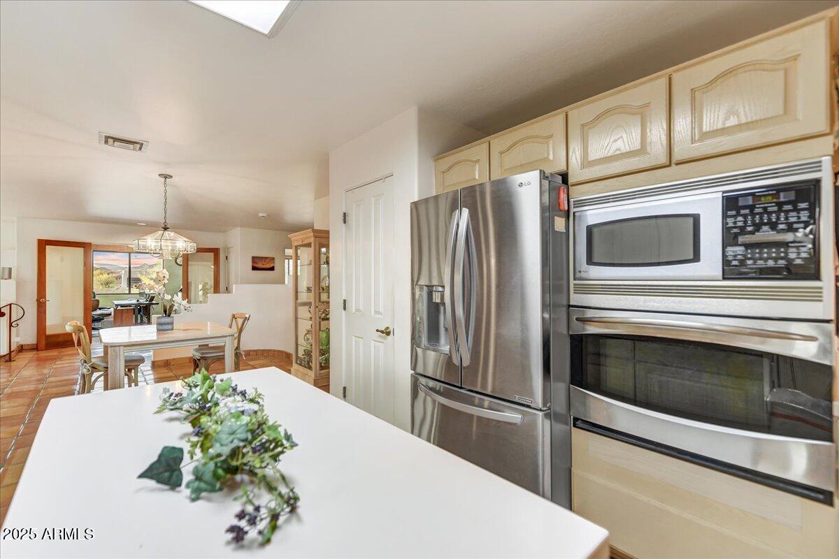 39258 North Ridgeway Drive Cave Creek, AZ 85331 - Photo 19 of 51 a kitchen with stainless steel appliances a refrigerator a stove a sink cabinets and a dining table