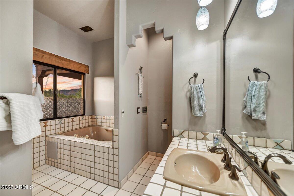 39258 North Ridgeway Drive Cave Creek, AZ 85331 - Photo 34 of 51 a bathroom with a tub sink and mirror