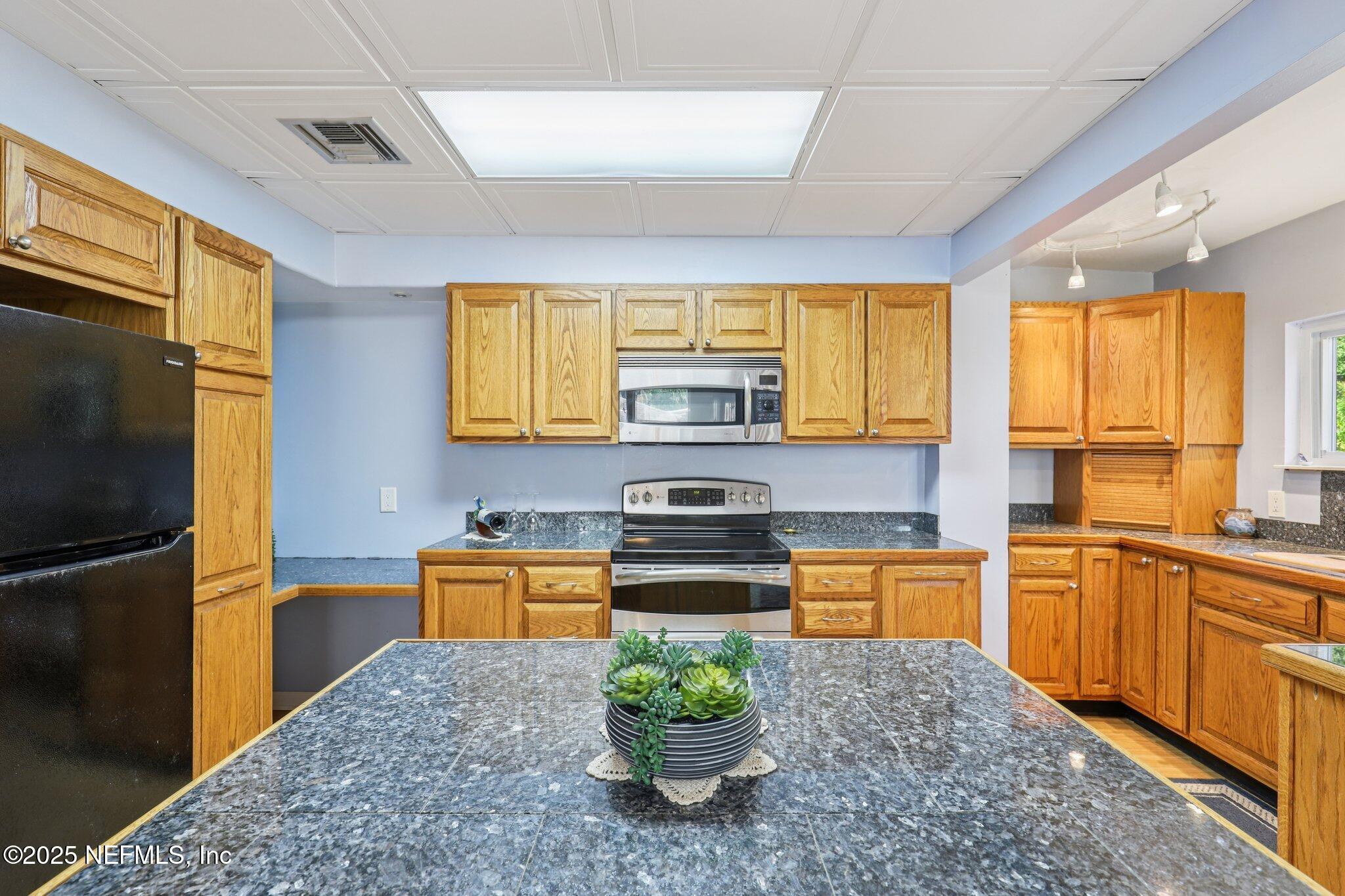 6470 Brooklyn Bay Road Keystone Heights, FL 32656 - Photo 13 of 56 a kitchen with stainless steel appliances granite countertop a stove a sink and a refrigerator