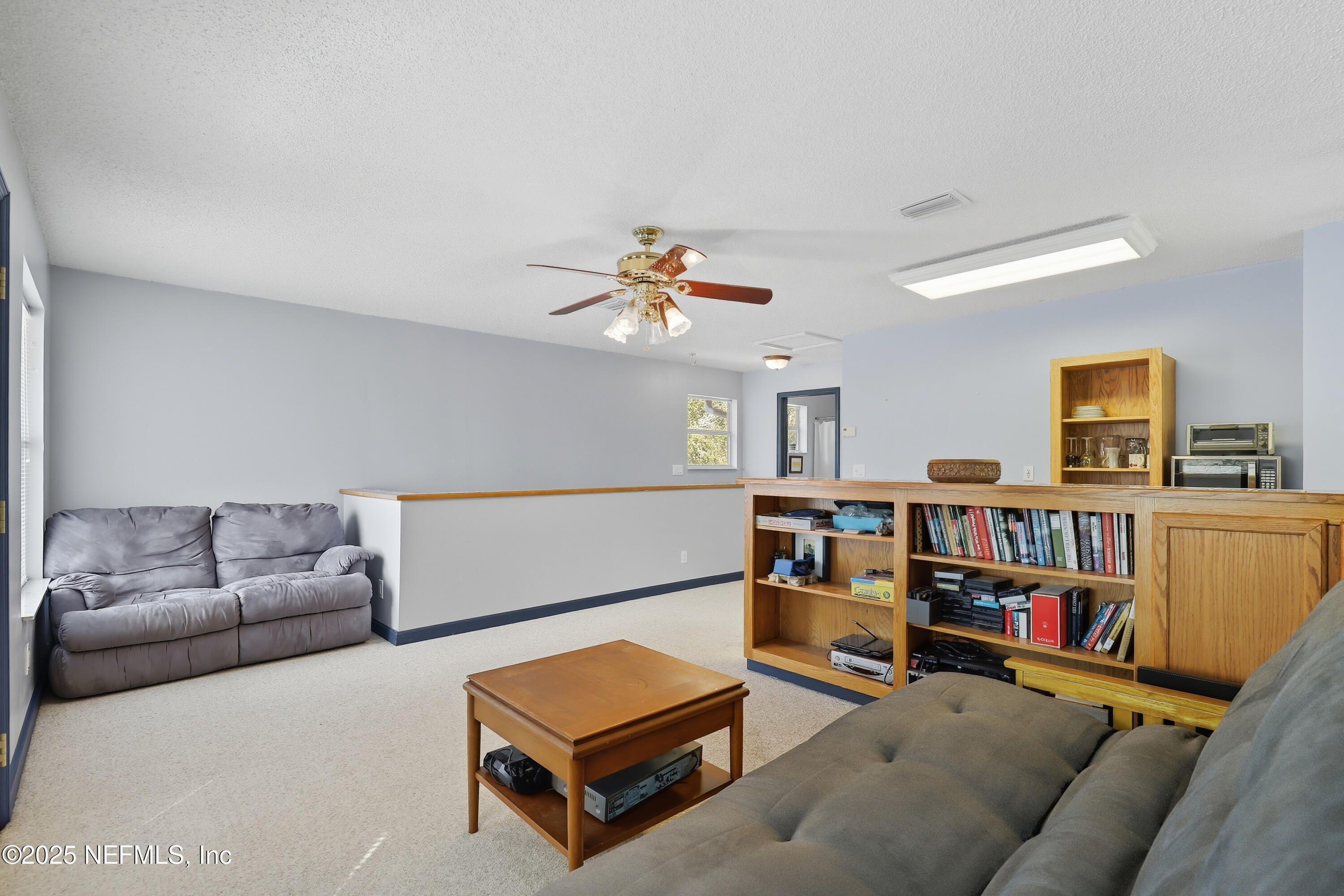 6470 Brooklyn Bay Road Keystone Heights, FL 32656 - Photo 27 of 56 a living room with furniture and a book shelf