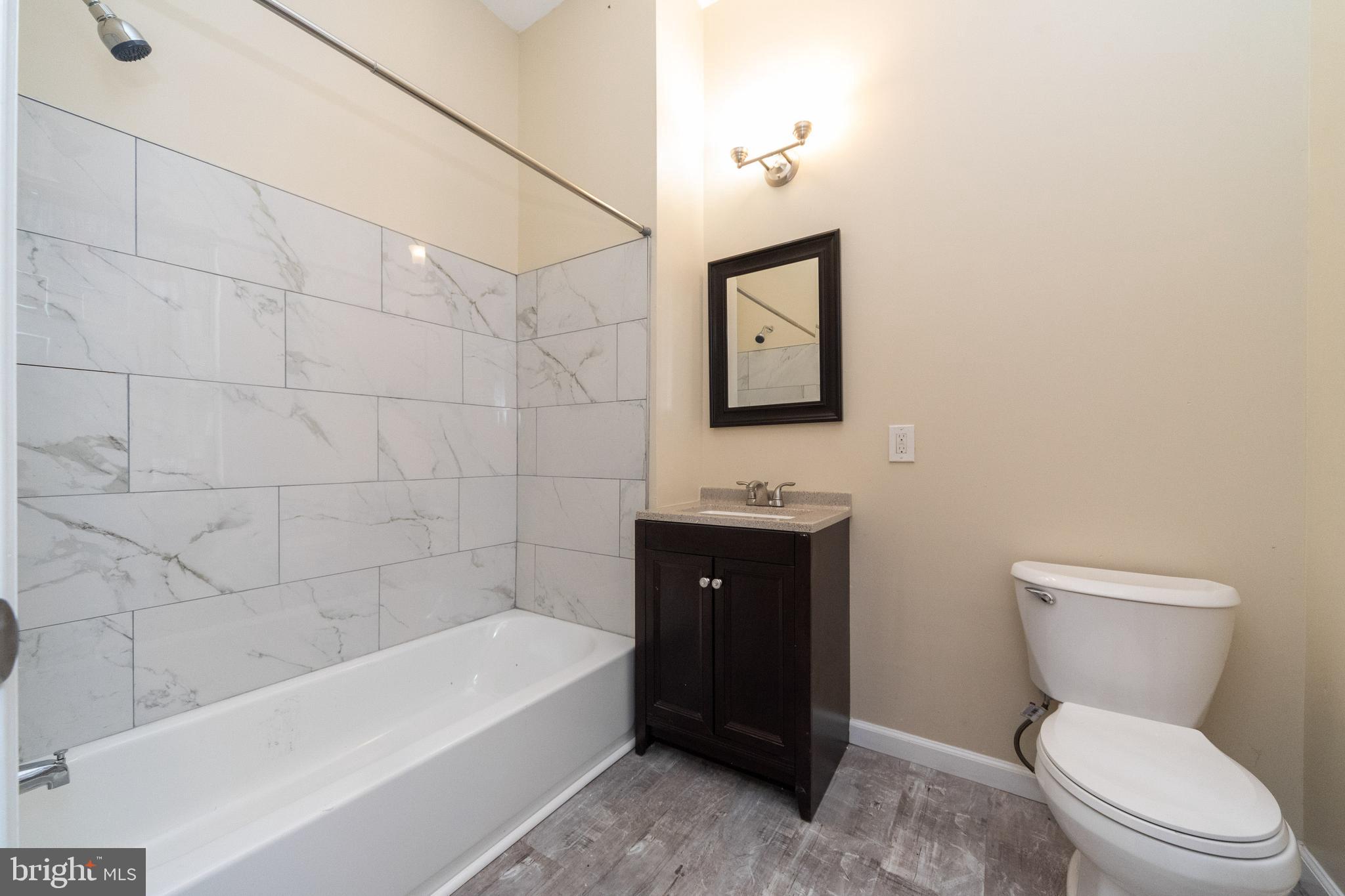 1708 Madison Avenue Baltimore, MD 21217 - Photo 17 of 56 a bathroom with a toilet a sink and bathtub