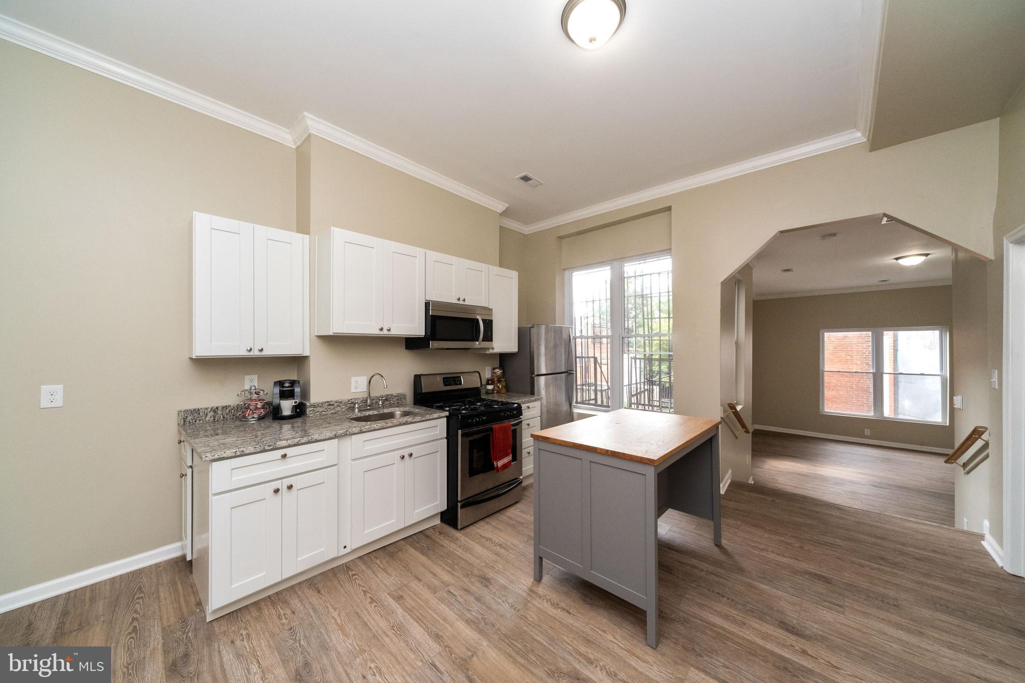 1708 Madison Avenue Baltimore, MD 21217 - Photo 23 of 56 a kitchen with granite countertop a sink appliances cabinets and wooden floor