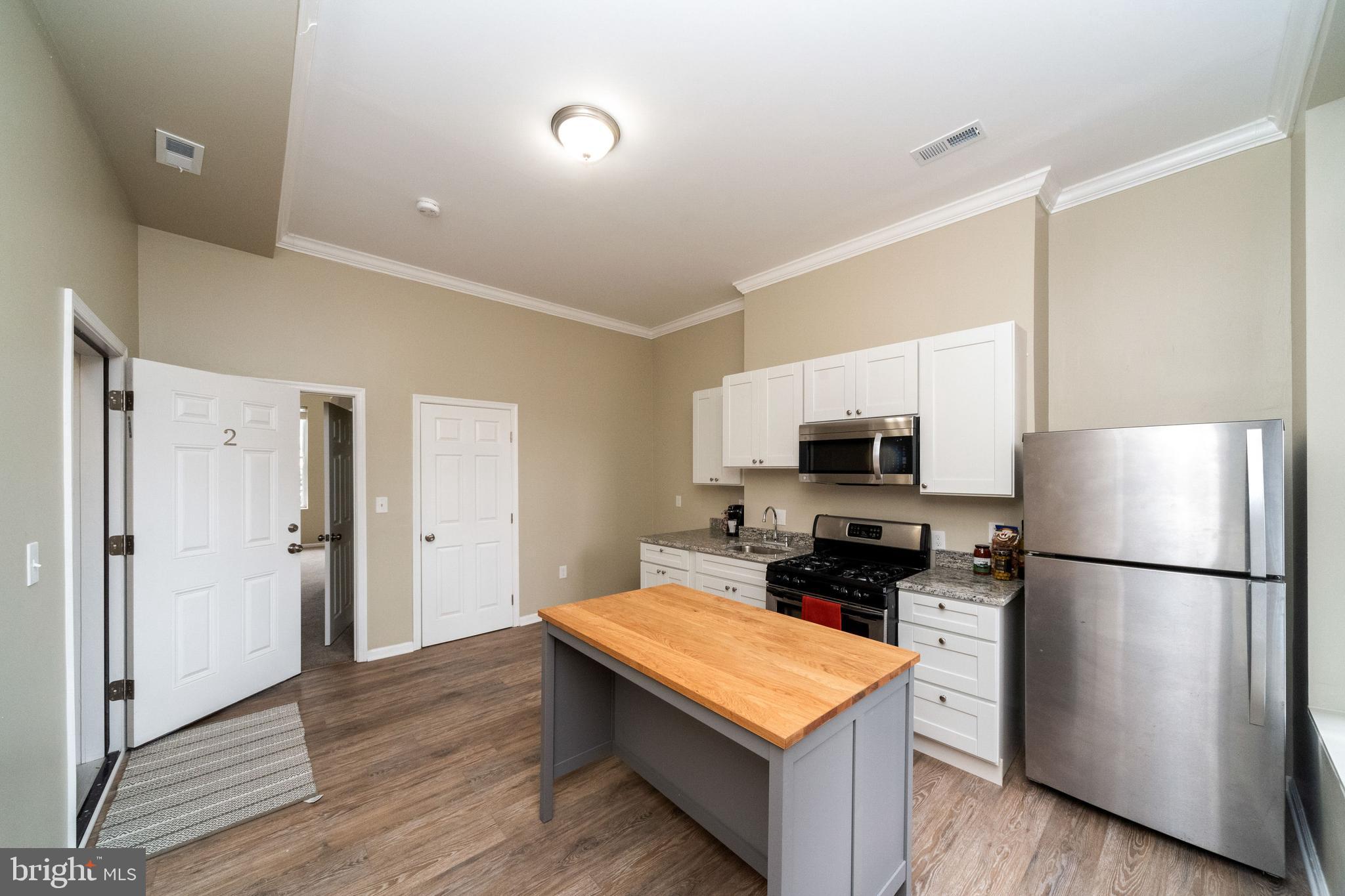1708 Madison Avenue Baltimore, MD 21217 - Photo 24 of 56 a kitchen with stainless steel appliances a refrigerator stove and microwave