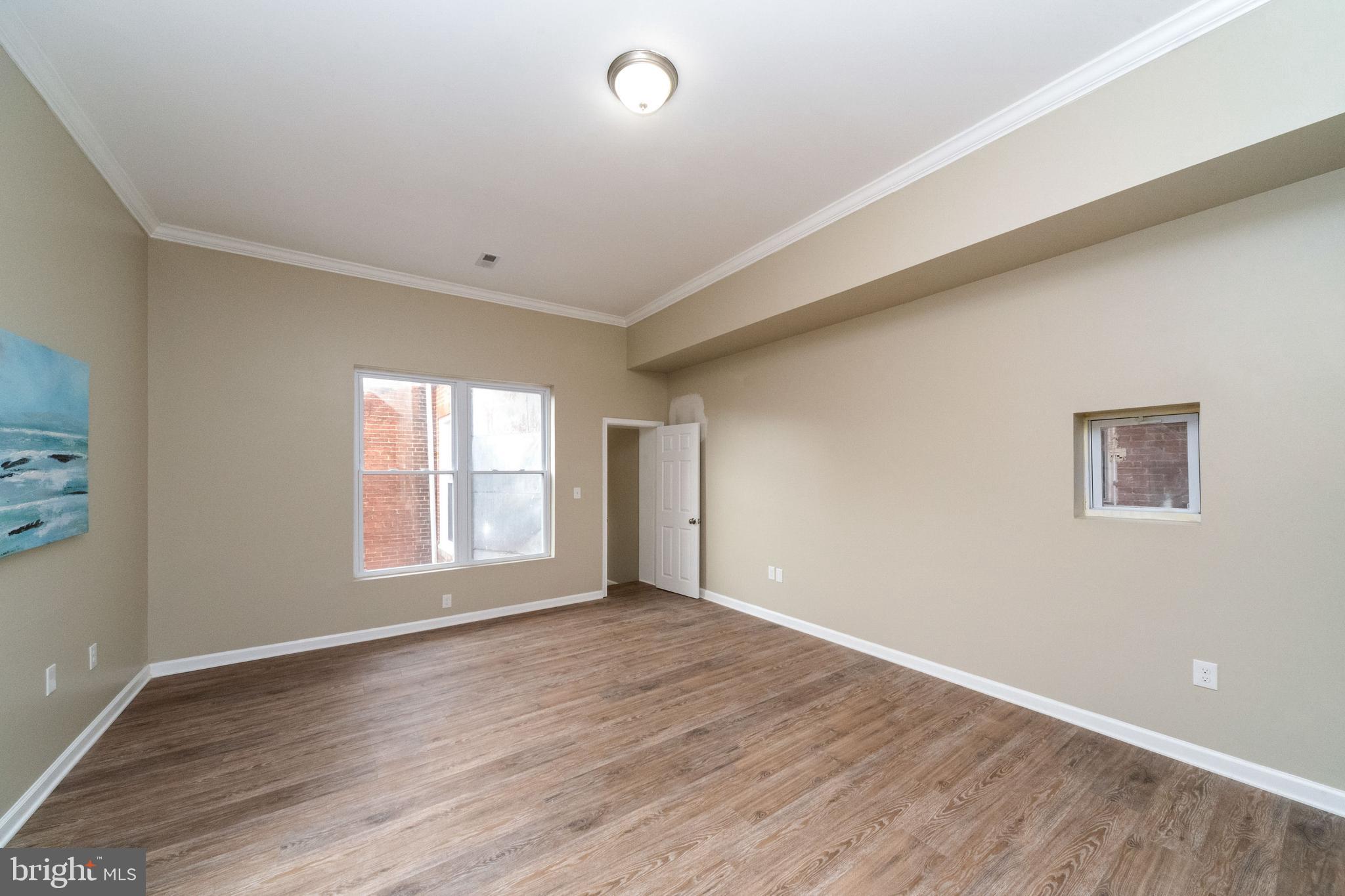 1708 Madison Avenue Baltimore, MD 21217 - Photo 27 of 56 an empty room with wooden floor and windows