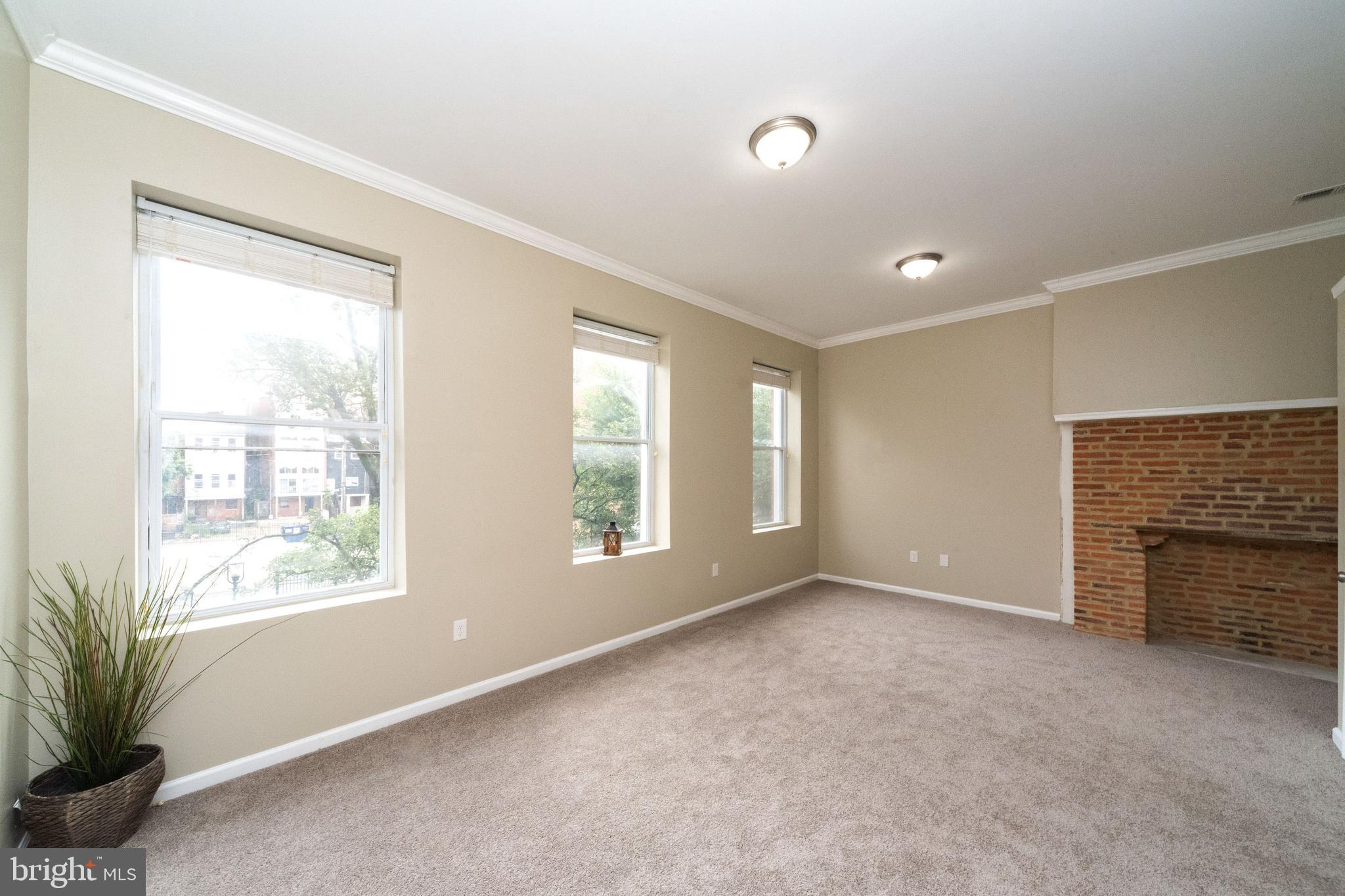 1708 Madison Avenue Baltimore, MD 21217 - Photo 35 of 56 an empty room with windows and fireplace