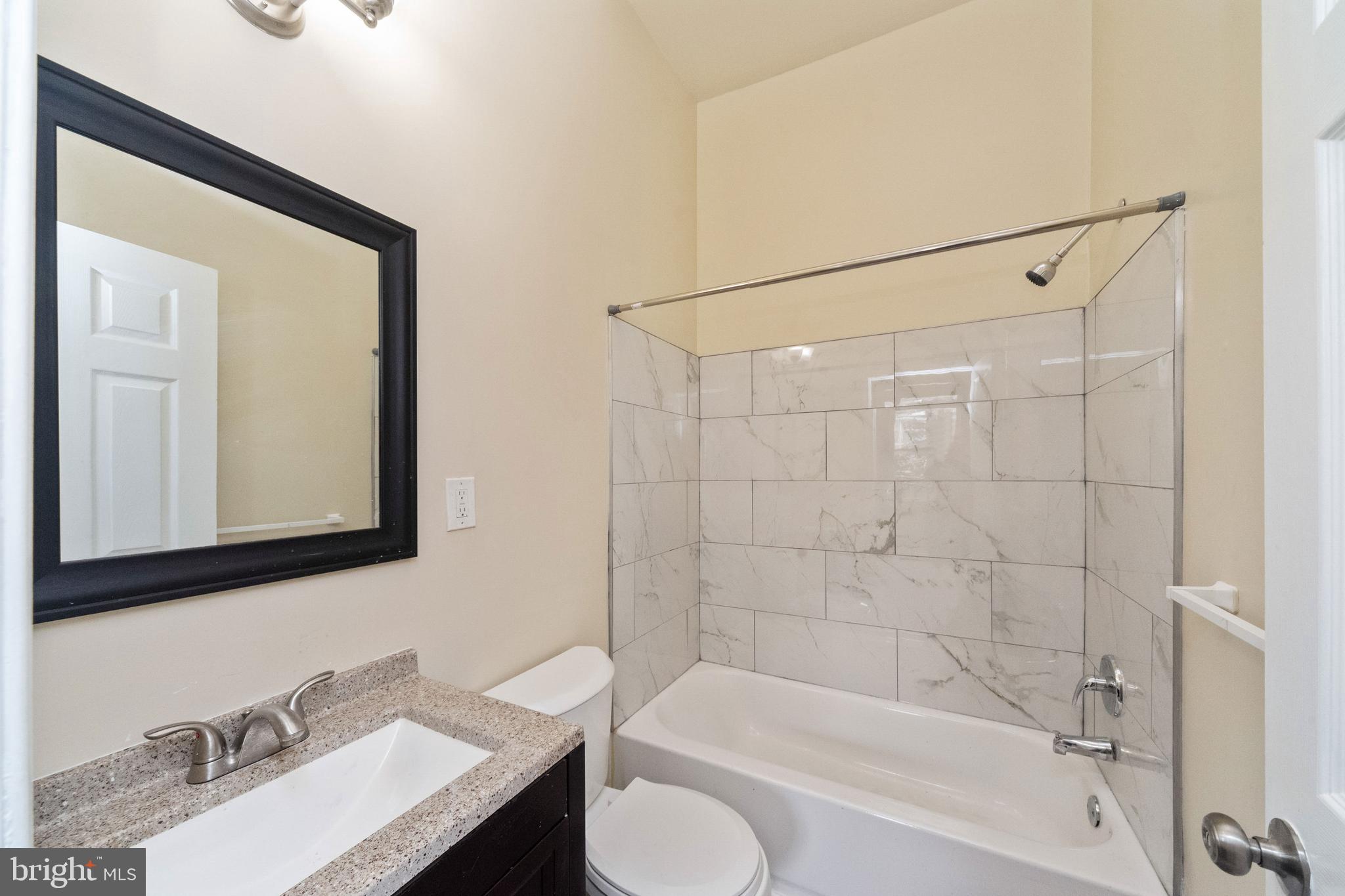 1708 Madison Avenue Baltimore, MD 21217 - Photo 38 of 56 a bathroom with a granite countertop sink toilet and shower