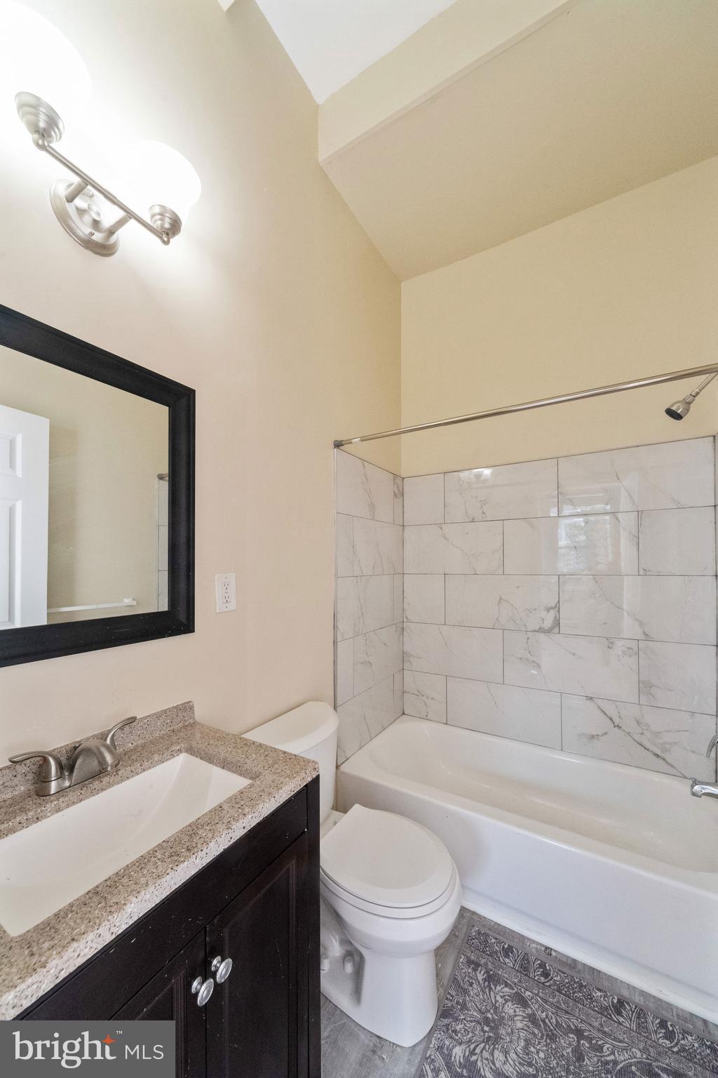 1708 Madison Avenue Baltimore, MD 21217 - Photo 39 of 56 a bathroom with a bathtub a sink a toilet a mirror and shower