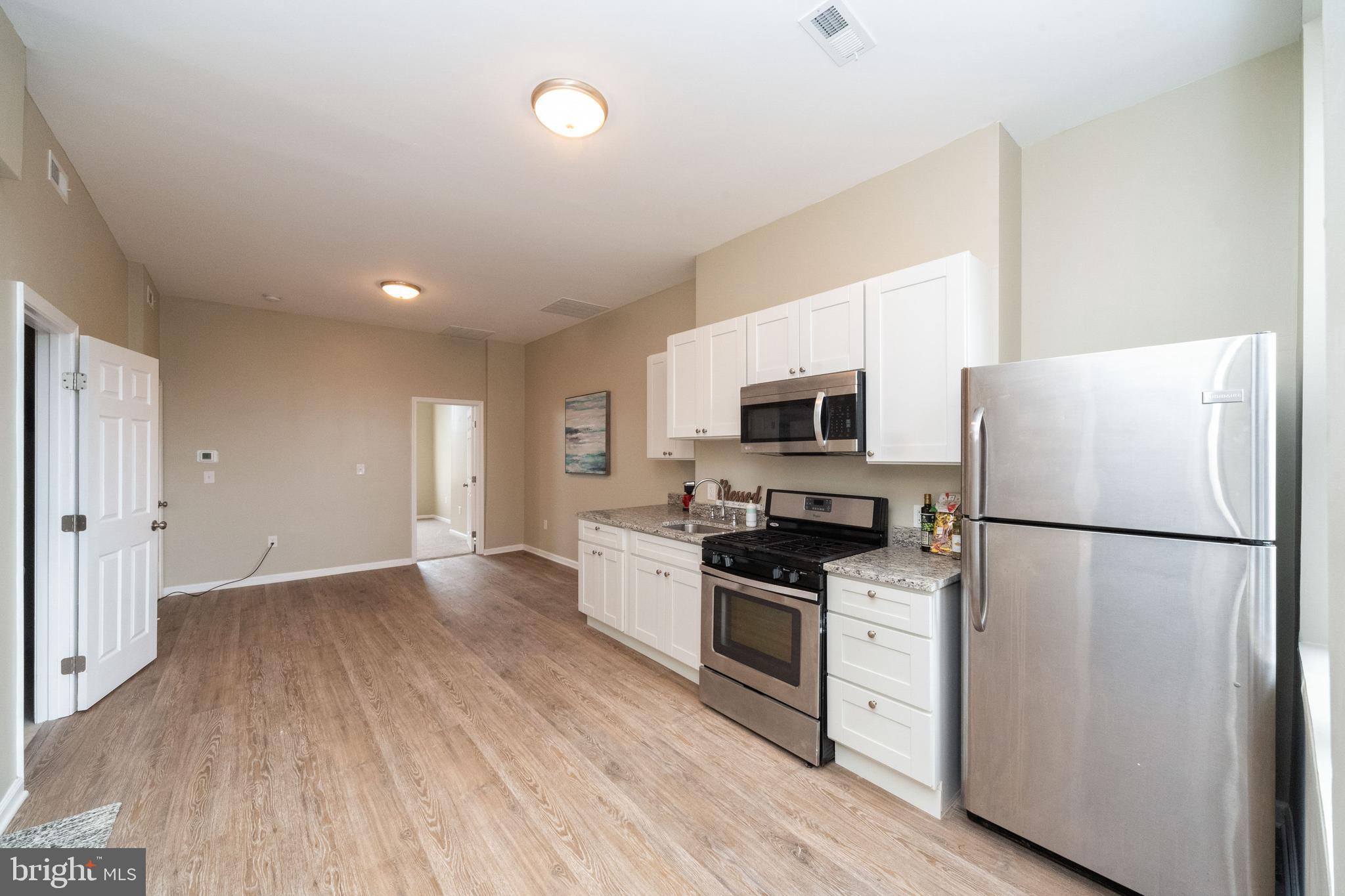 1708 Madison Avenue Baltimore, MD 21217 - Photo 43 of 56 a kitchen with stainless steel appliances a refrigerator sink and microwave