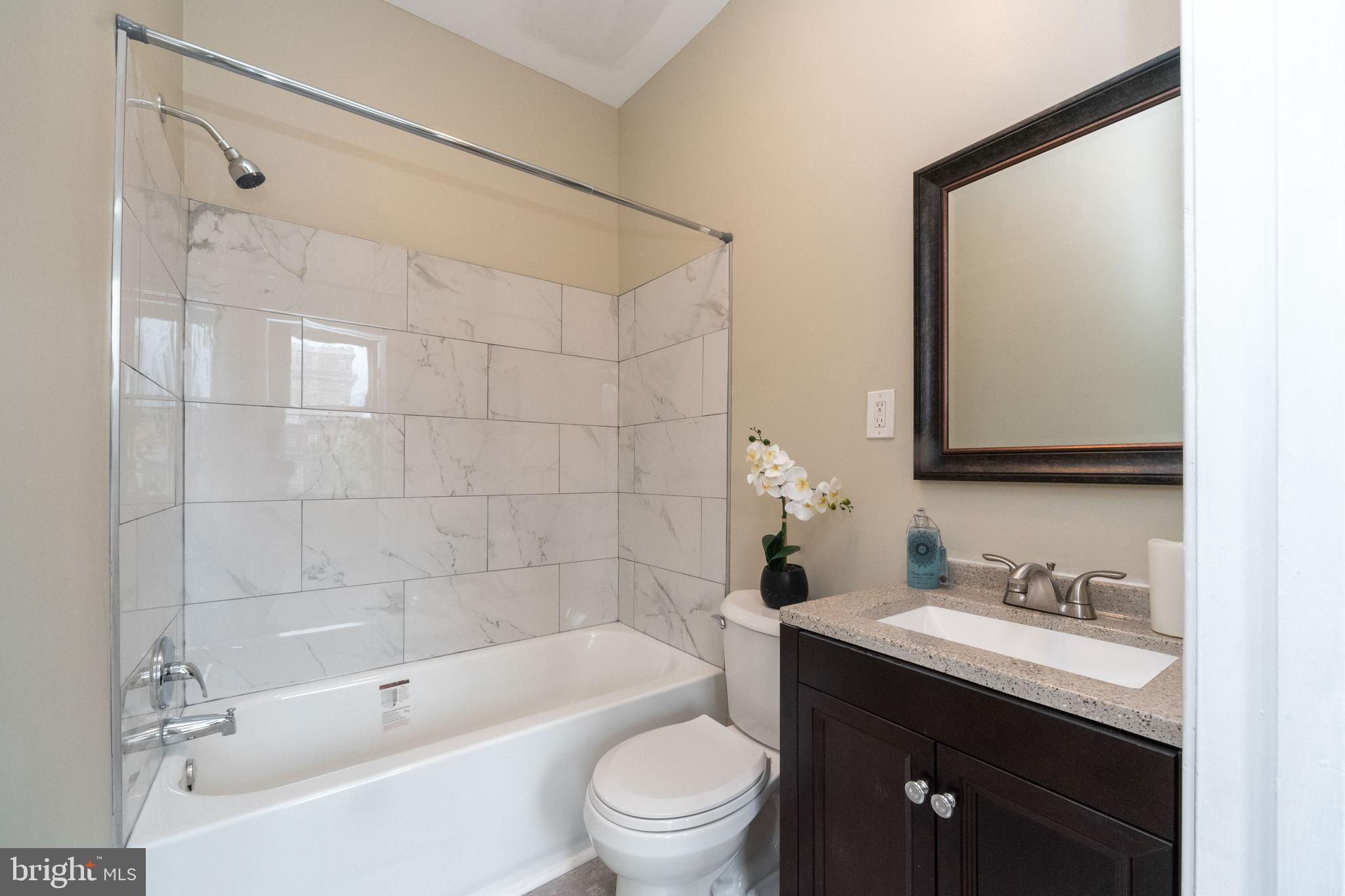 1708 Madison Avenue Baltimore, MD 21217 - Photo 48 of 56 a bathroom with a granite countertop sink a toilet and shower