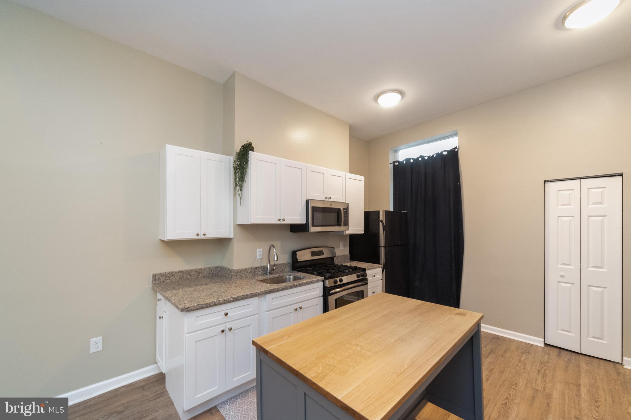 1708 Madison Avenue Baltimore, MD 21217 - Photo 5 of 56 a kitchen with stainless steel appliances granite countertop a refrigerator stove microwave and sink