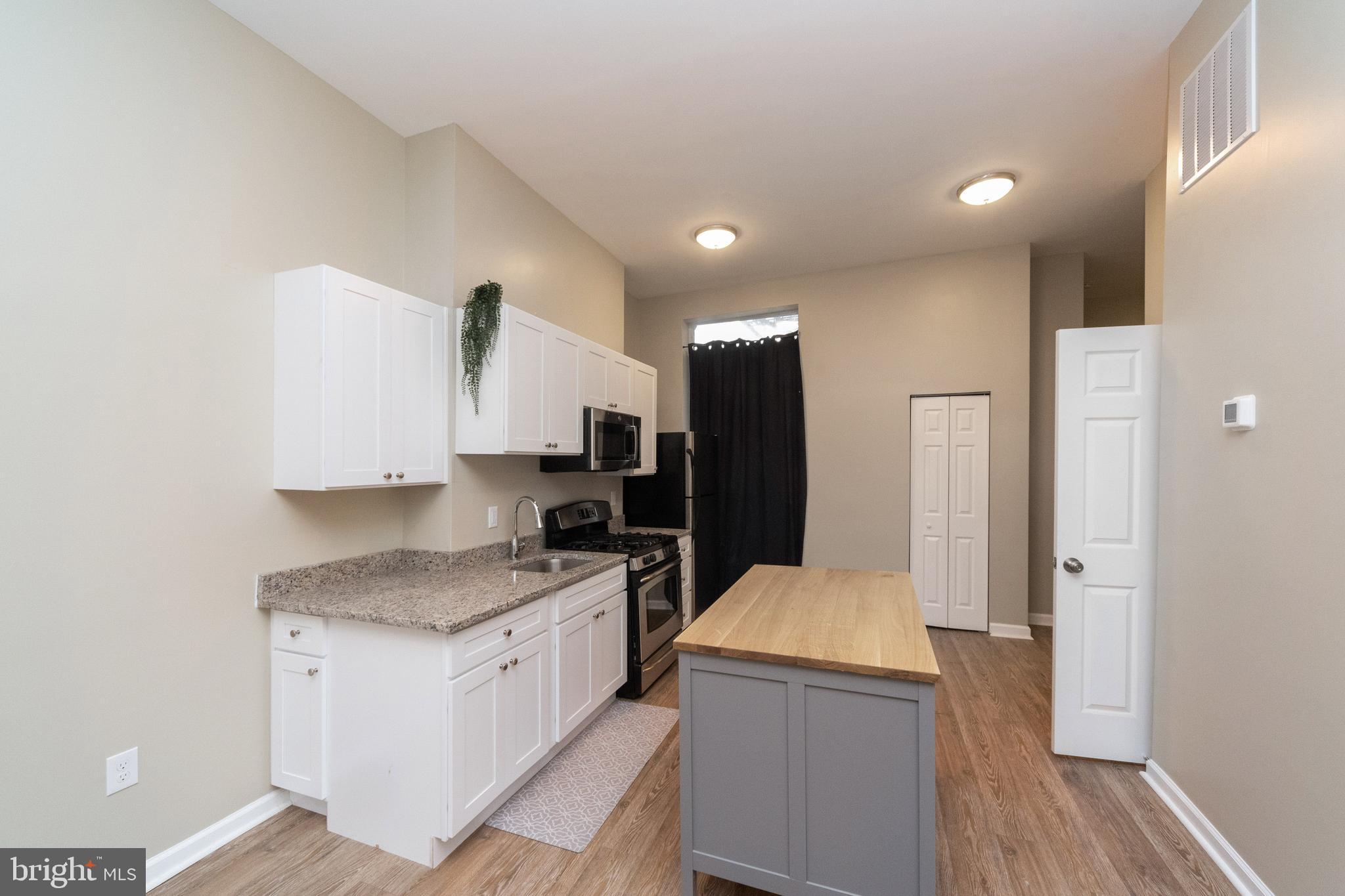 1708 Madison Avenue Baltimore, MD 21217 - Photo 6 of 56 a kitchen with a refrigerator and a stove top oven