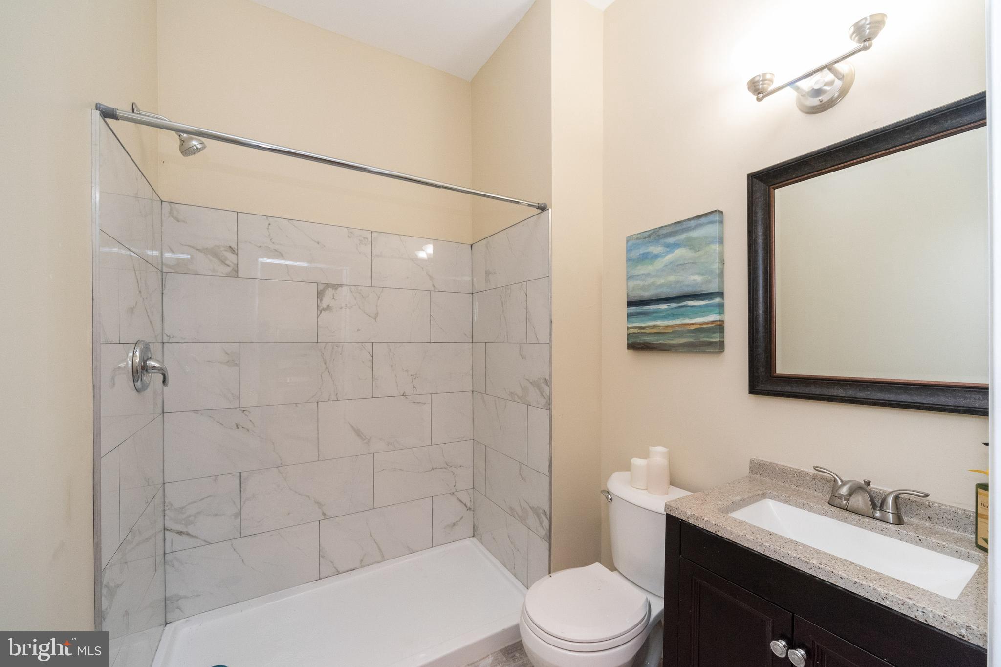 1708 Madison Avenue Baltimore, MD 21217 - Photo 8 of 56 a bathroom with a sink toilet vanity and shower