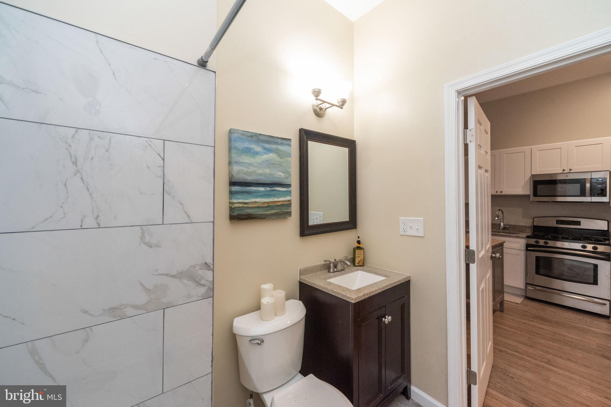 1708 Madison Avenue Baltimore, MD 21217 - Photo 9 of 56 a bathroom with a toilet sink and mirror