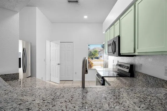 a kitchen with stainless steel appliances granite countertop a refrigerator and a sink