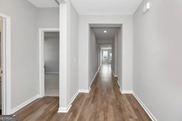 a view of a hallway with wooden floor
