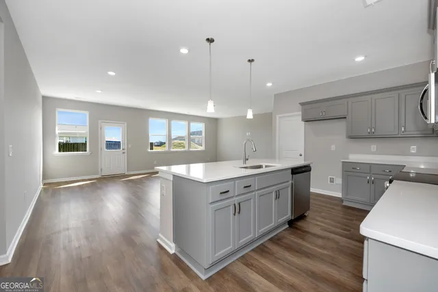 a large kitchen with stainless steel appliances granite countertop a lot of counter space and wooden floor