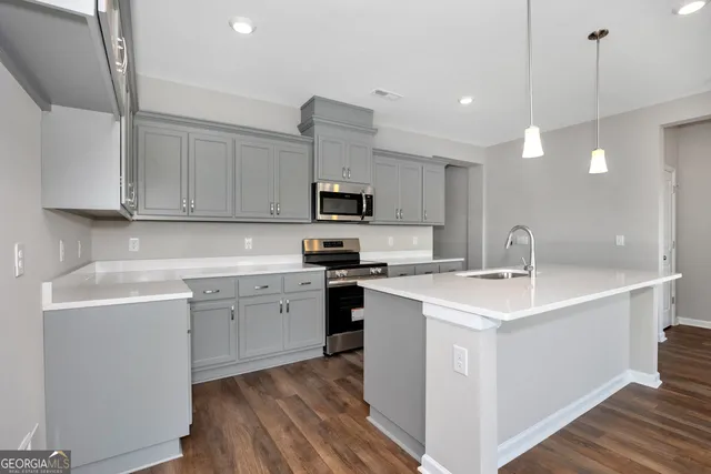 a kitchen with a sink cabinets and wooden floor